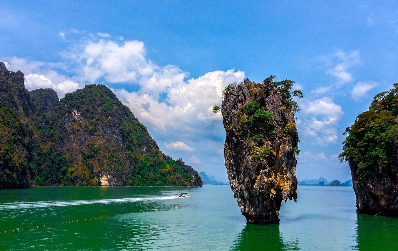 Ko Tapu pinnacle at James Bond Island with a passing speedboat
