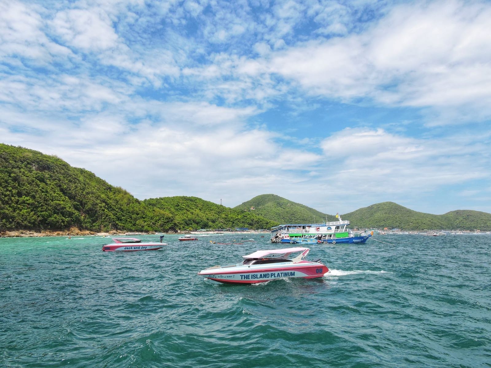 Speedboats near Koh Larn with green hills behind
