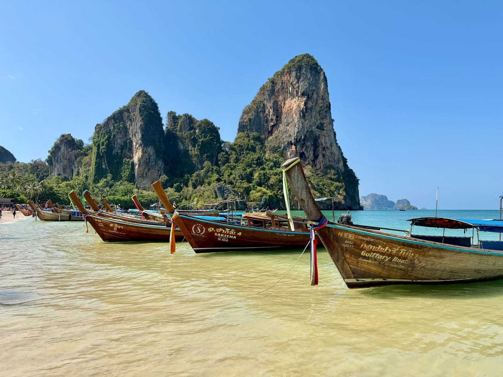 Longtail boats on the sand at Railay under limestone cliffs